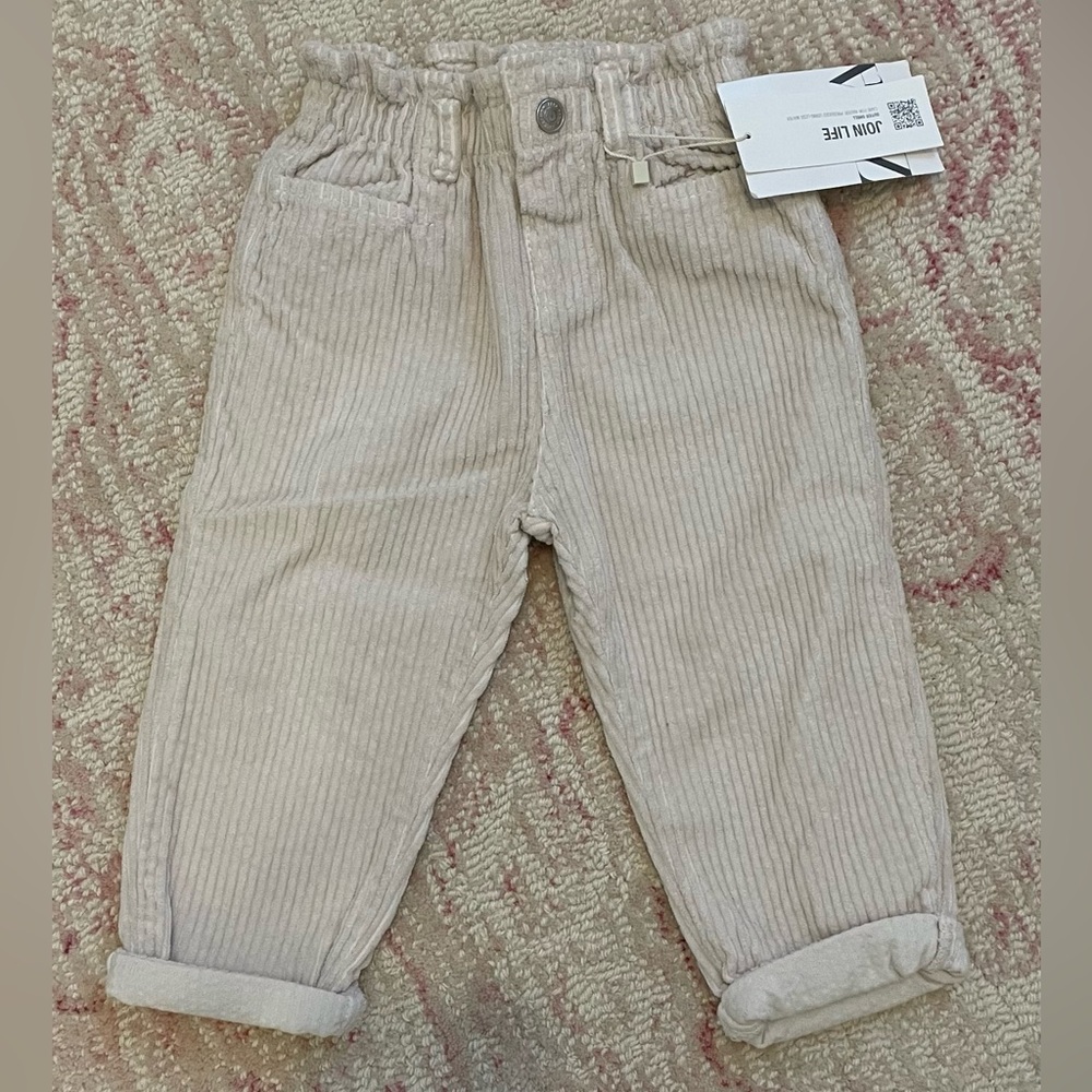 Blush pink corduroy pants with elastic waist.